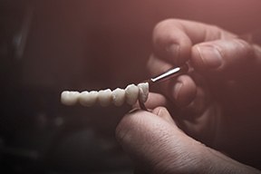 Lab technician painting teeth