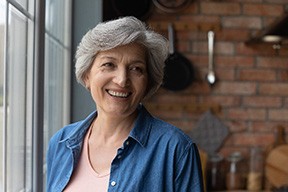 Senior woman smiling by a window