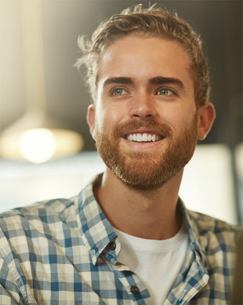 a smiling man wearing a plaid shirt