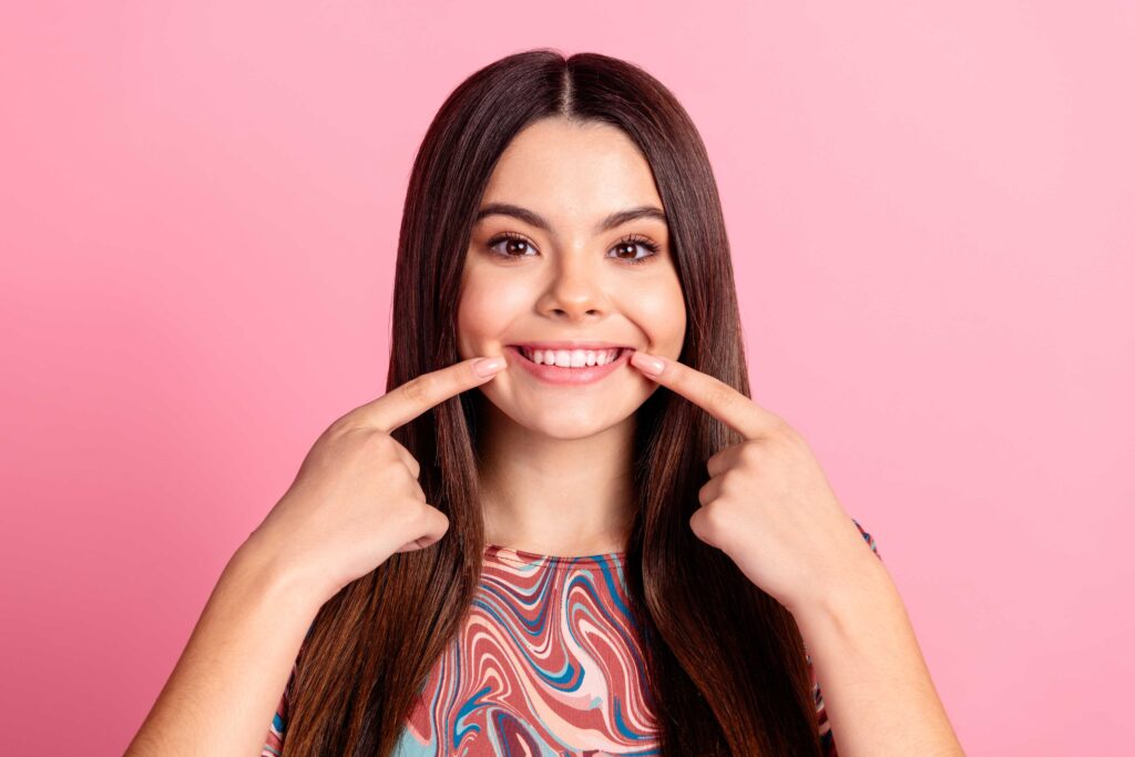 Woman pointing to her smile